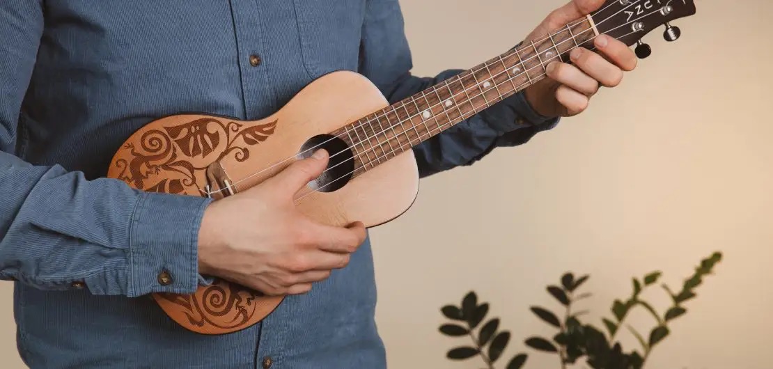 Hands holding a ukulele, close-up view