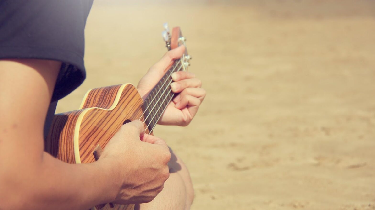 The hands of a man who plays the ukulele