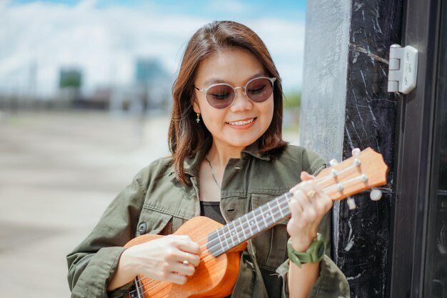Girl with glasses plays the ukulele